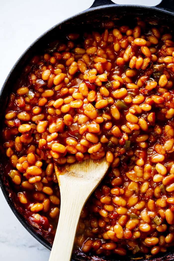 Southern baked beans with caramelized onions and green pepper in a baking dish