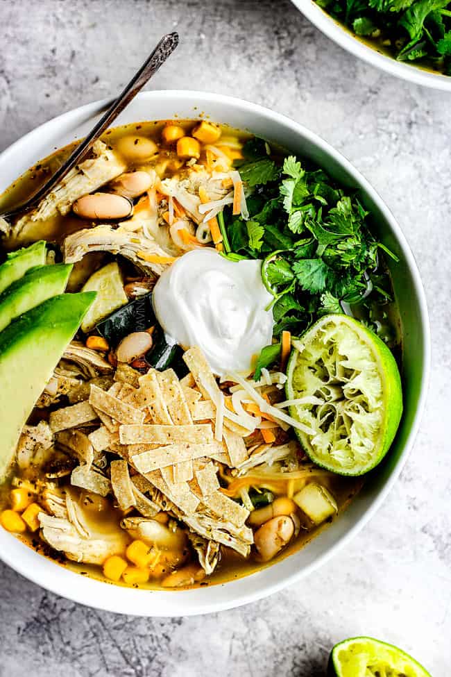 Crockpot salsa verde chicken tortilla soup with avocado, cilantro and baked tortilla strips