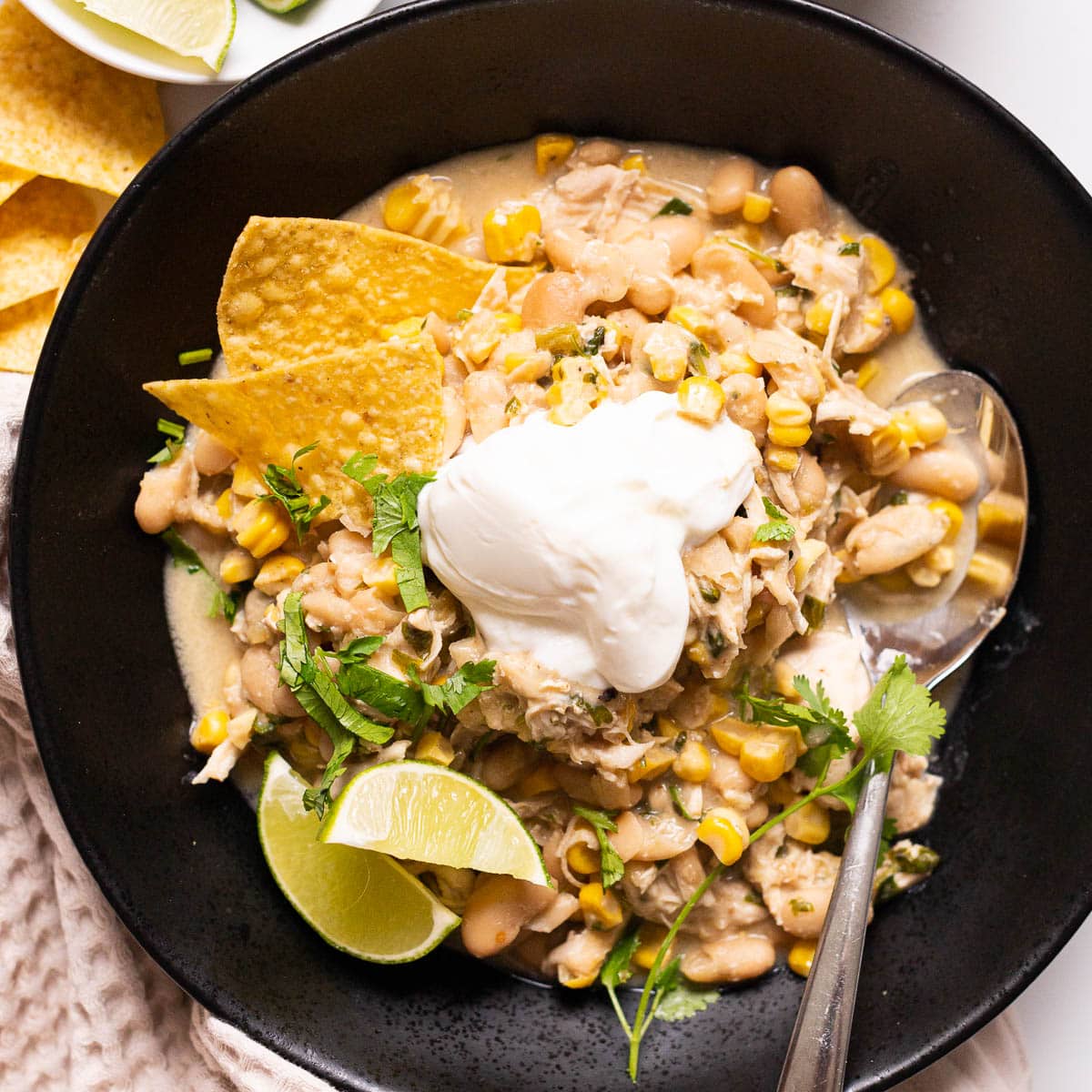 Crockpot white chicken chili with creamy broth, white beans and corn in a bowl