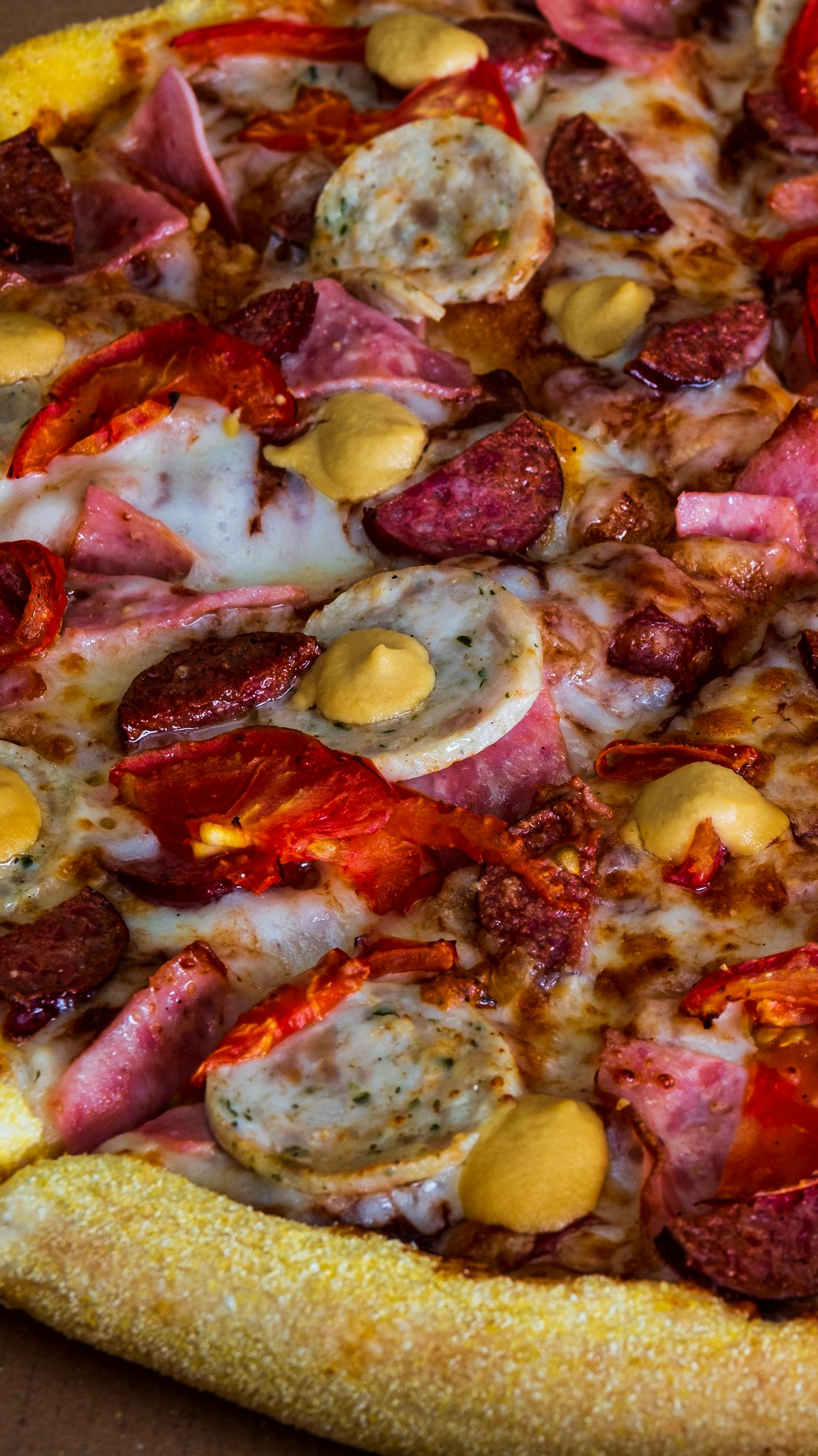 Mouth-watering close-up of a loaded sausage and pepperoni pizza, showcasing vibrant toppings.