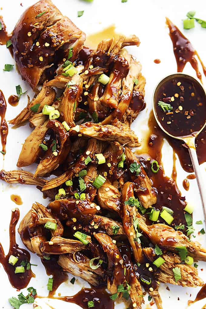Slow cooker honey garlic chicken shredded in sticky sauce over white rice